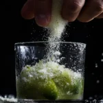 Muddling fresh lime with sugar for a classic Caipirinha